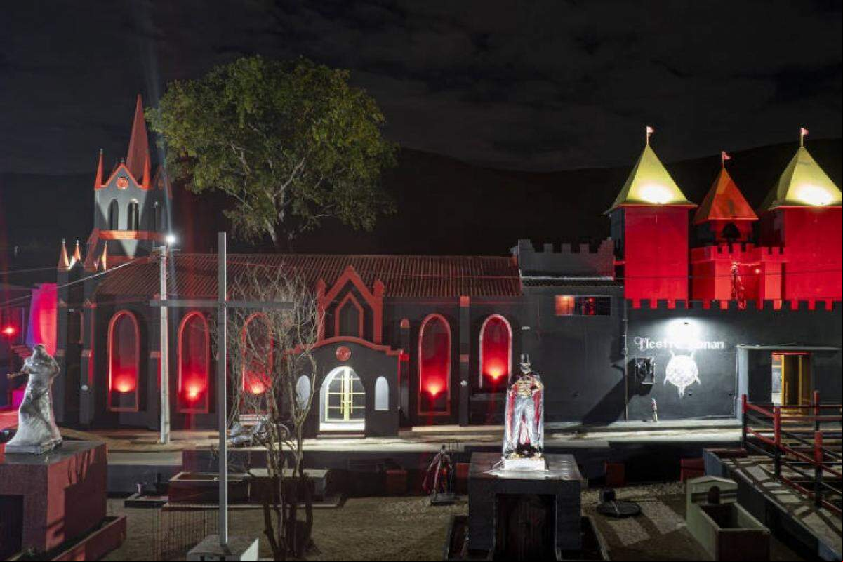 Pintada de preto com detalhes em vermelho, igreja exibe cruzes de ponta-cabeça